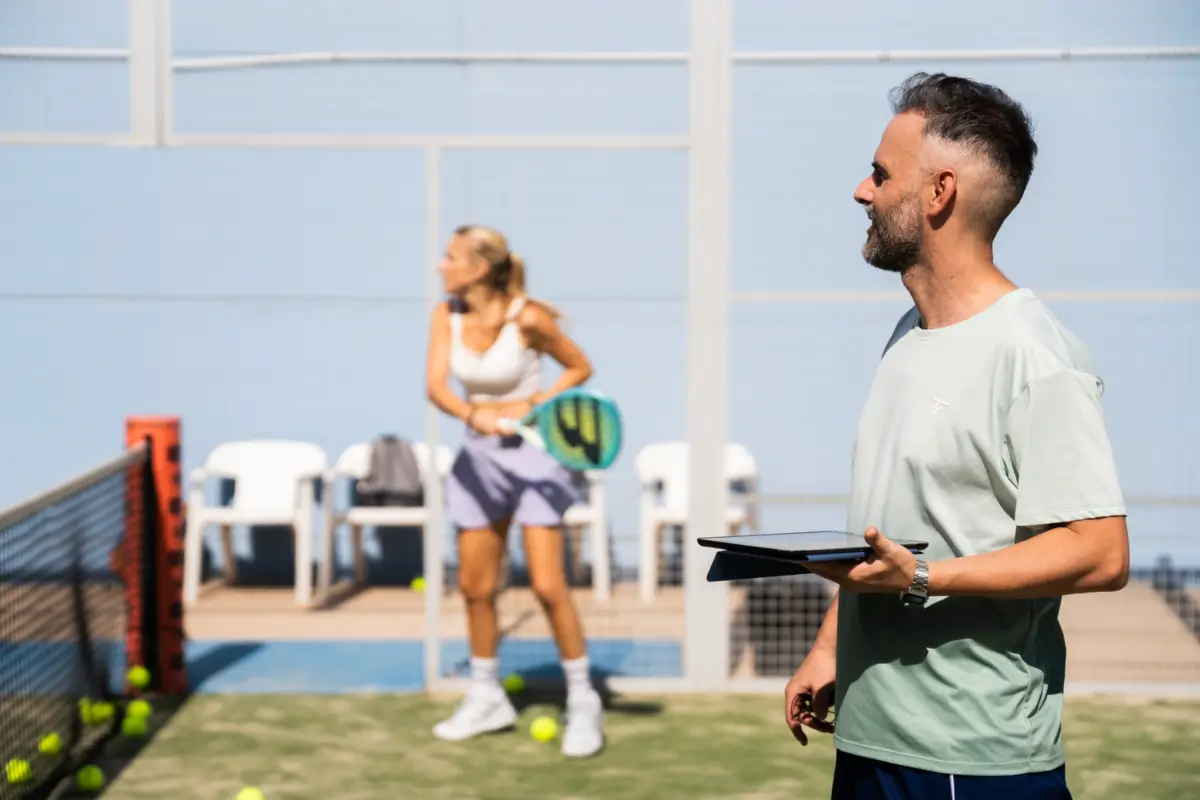 Iván coaching a player on court during a padel lesson in Valencia