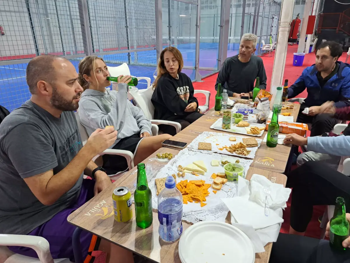Players sharing drinks and snacks courtside after a session